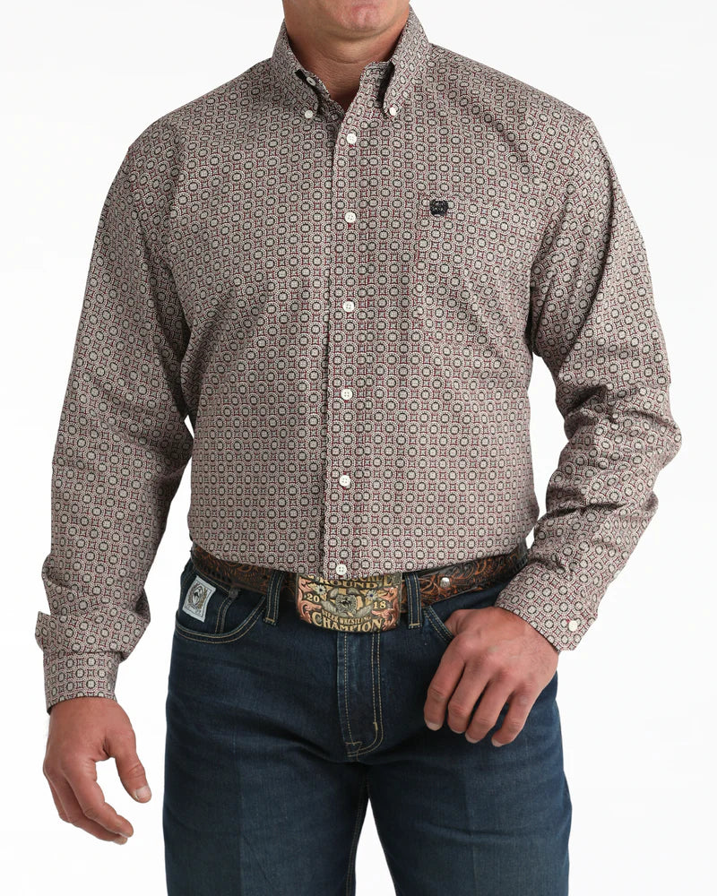 Man wearing a patterned button-up shirt and jeans on a white background