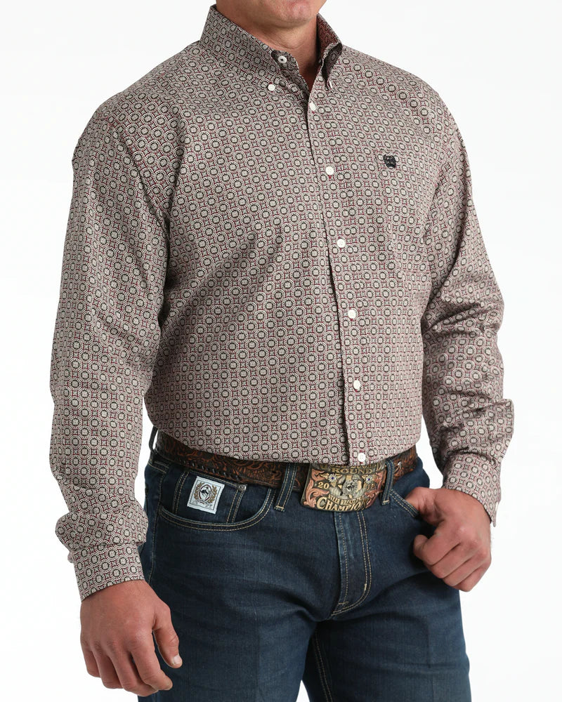 Man wearing a patterned shirt and jeans on a white background