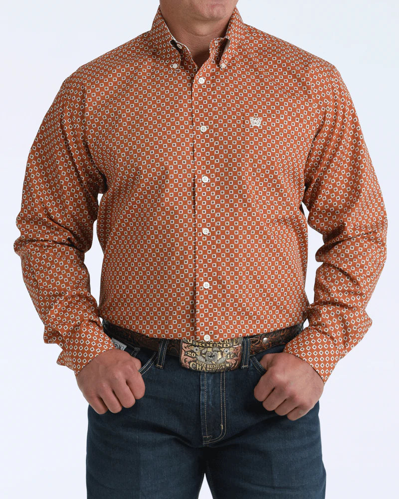 Man wearing a patterned brown shirt with a visible brand logo on a white background