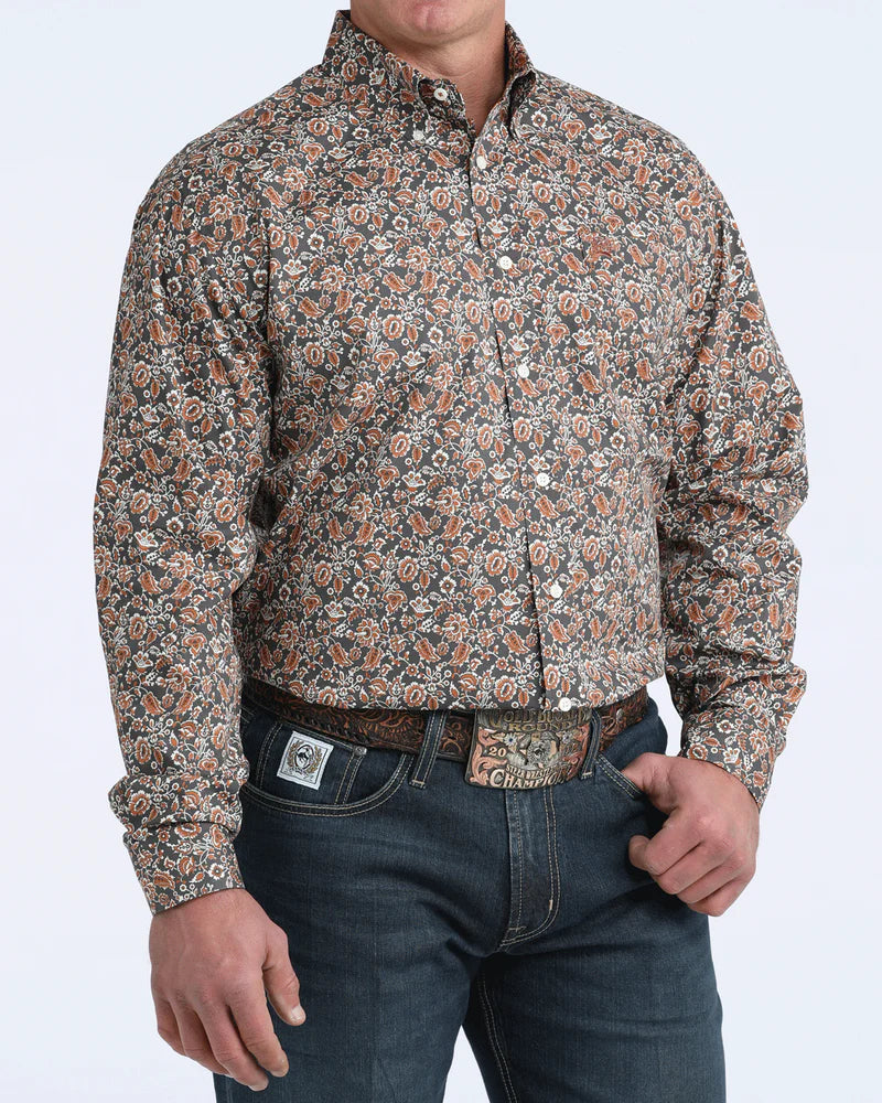 Man wearing a patterned shirt and jeans on a white background