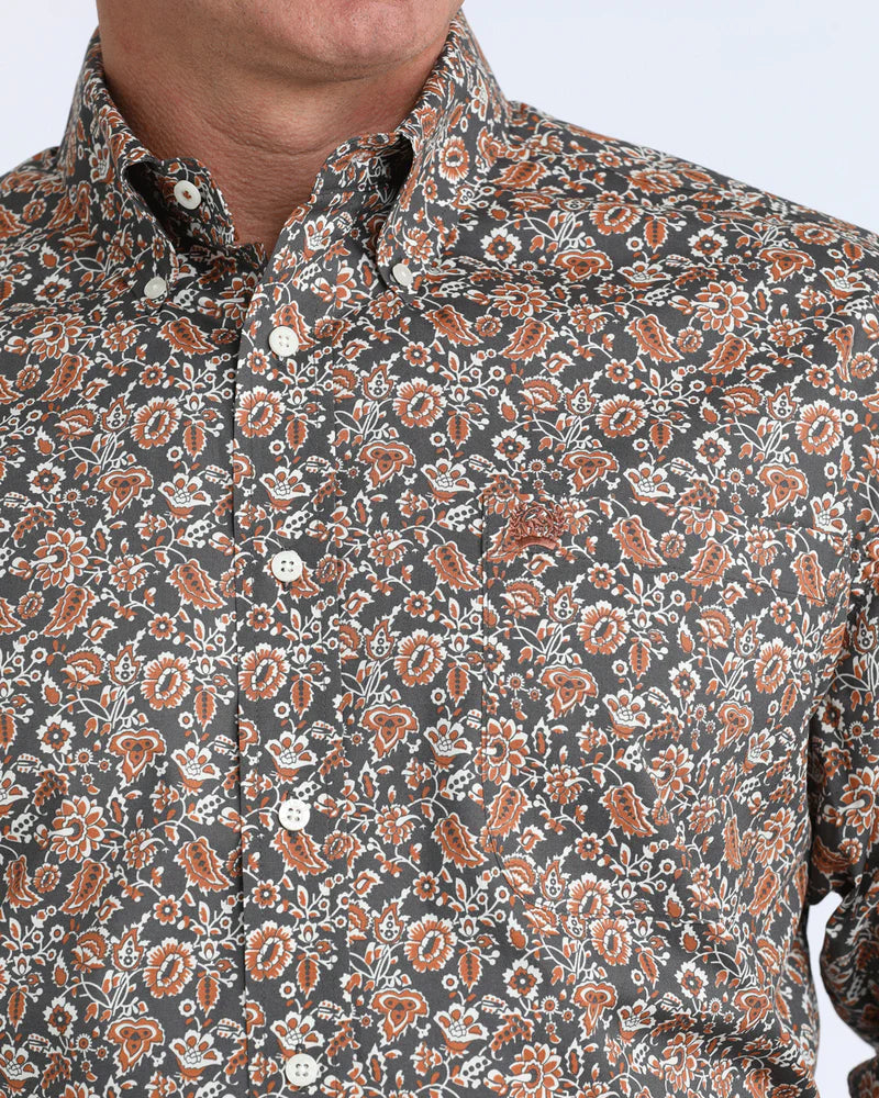 Close-up of a patterned shirt with brown and white floral design on a gray background