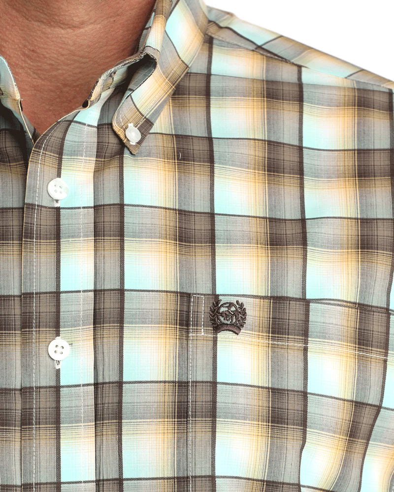 Close-up of a plaid shirt with a brand logo on a blurred background