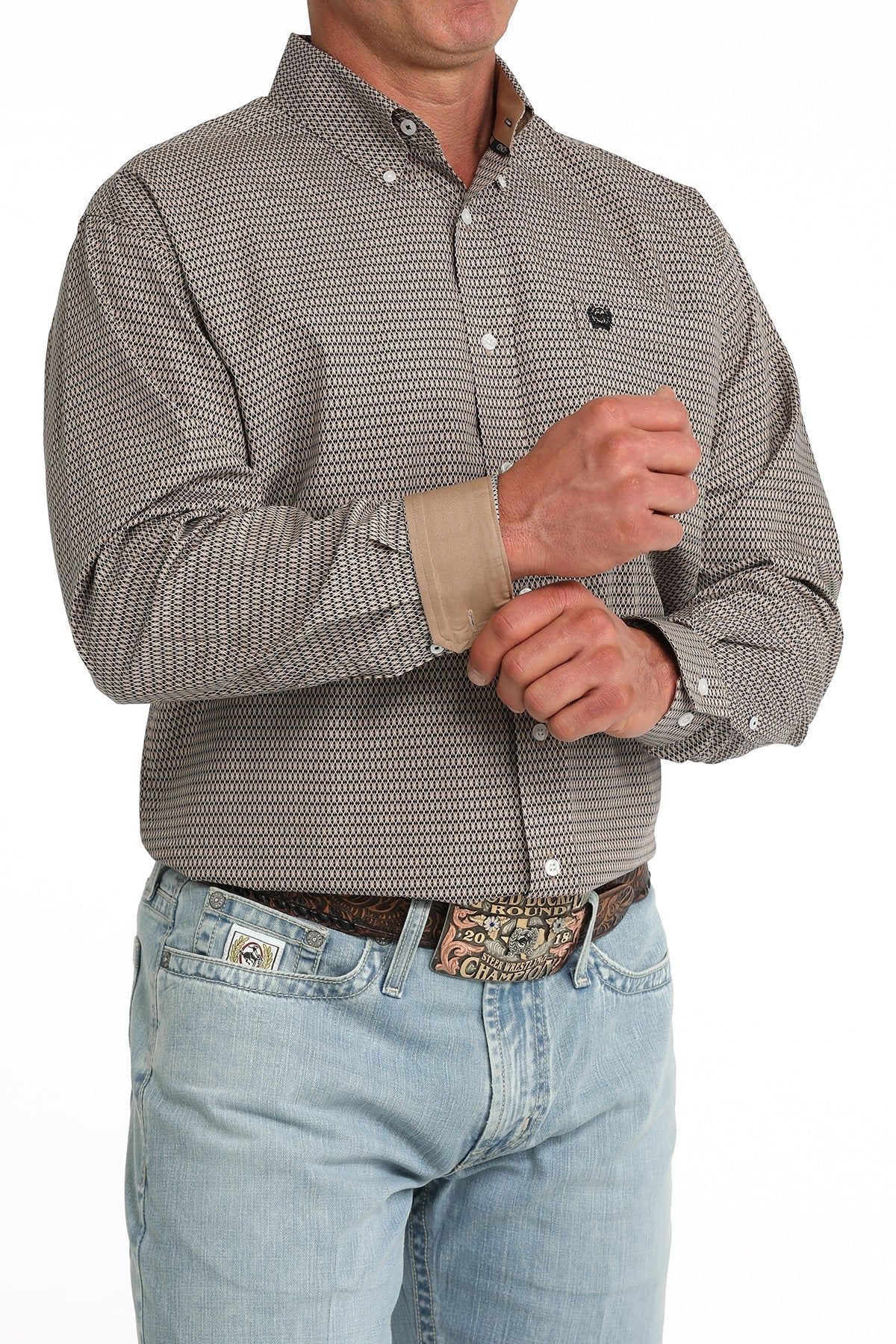 Man wearing a patterned shirt and jeans on a white background