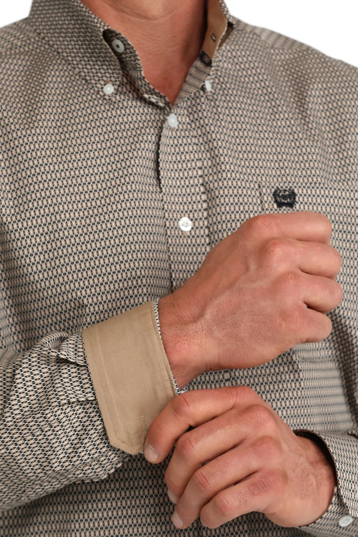 Close-up of a person wearing a patterned shirt with a focus on the sleeve and hand.