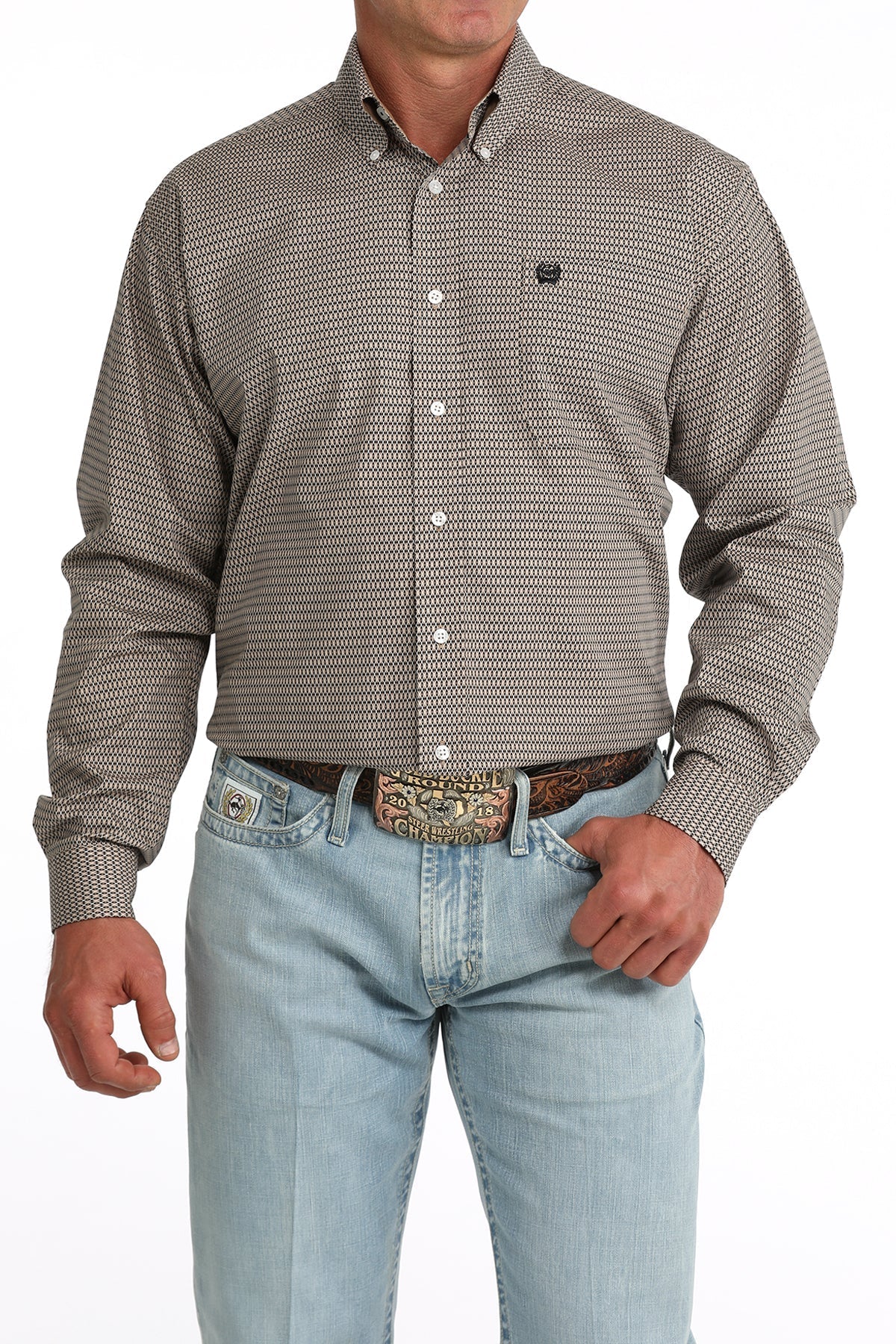 Man wearing a patterned long-sleeve shirt and light blue jeans on a white background