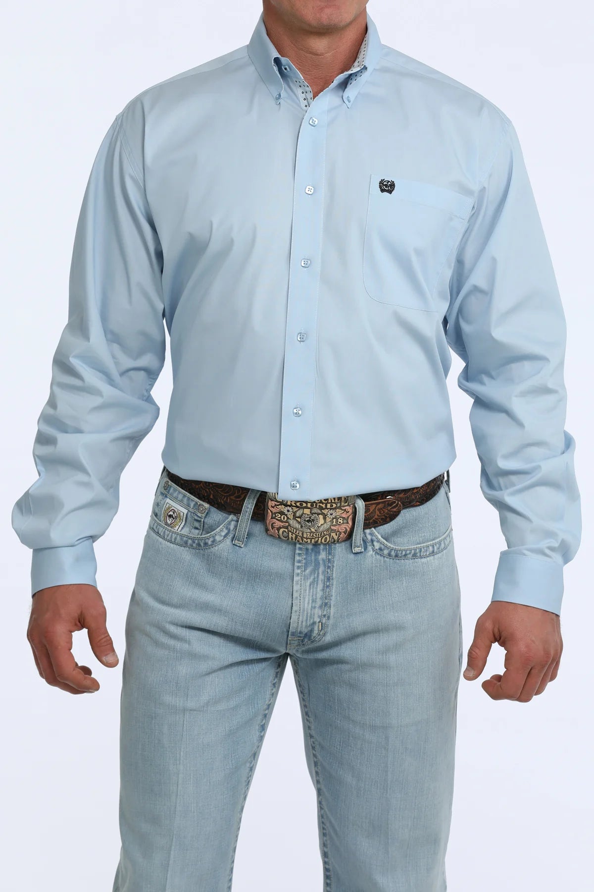 Man wearing a light blue button-up shirt and jeans on a white background