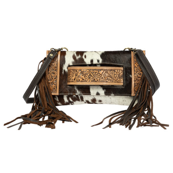Cowhide leather handbag with fringe and intricate designs on a white background