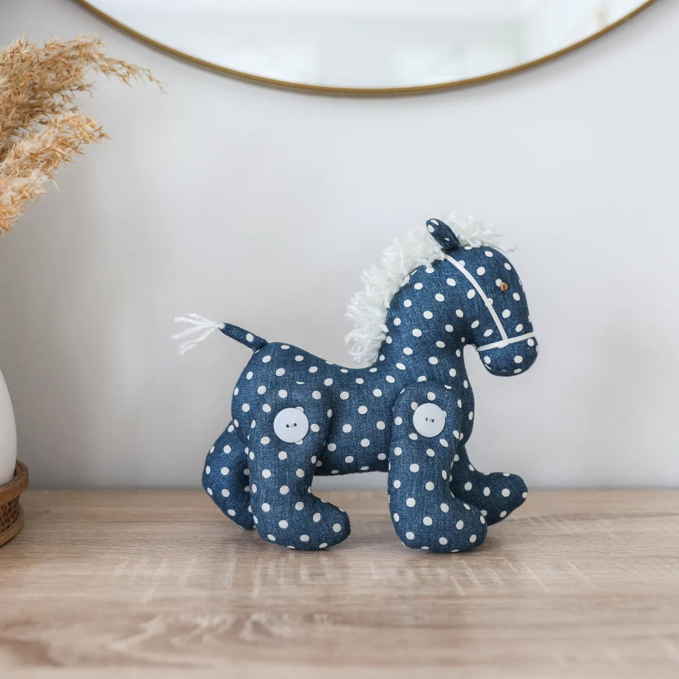 Stuffed horse toy with blue and white polka dot pattern on a white background