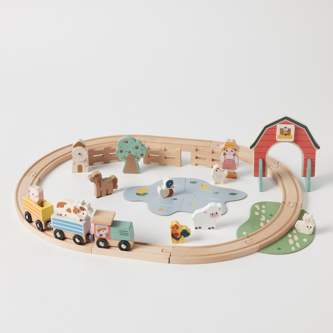 Wooden toy train set with animals and a barn on a white background
