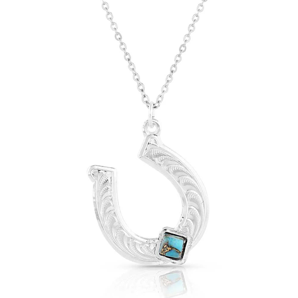 Montana Silversmiths Diamond Horseshoe Necklace. Silver necklace with a decorative pendant featuring a turquoise stone on a white background