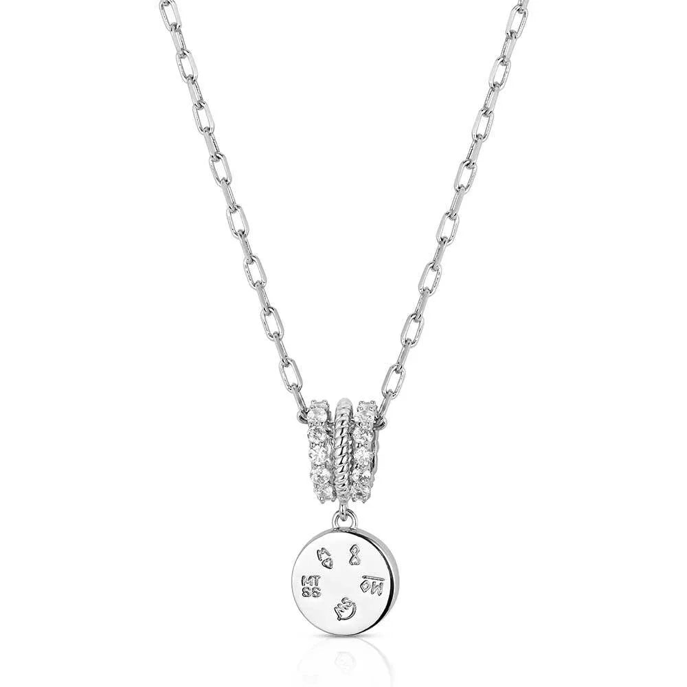 Silver necklace with a round pendant on a white background