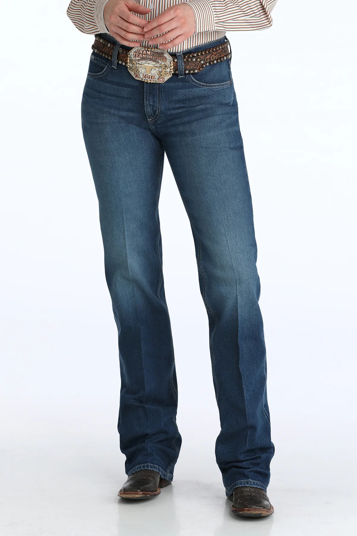 Person wearing blue jeans with a decorative belt on a white background