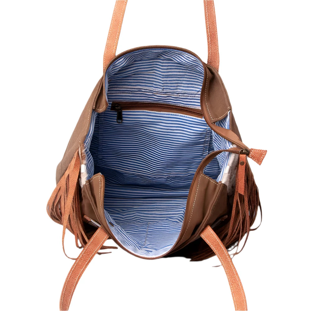 A brown and beige women's handbag with leather fringes and a 'Vintage' print on the front, featuring a star and the text 'American Darling'.