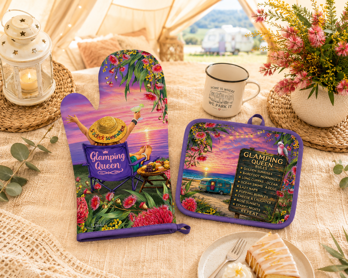 A matching cookware set displayed on a tablecloth in a styled outdoor-themed setting. The set includes a purple oven mitt and a square pot holder with a tropical beach scene, pink flowers, a green sombrero, and a 'Glamping Queen' sign.