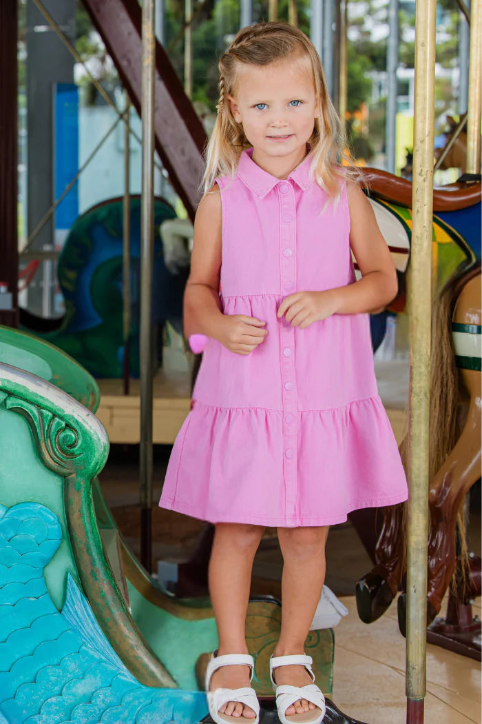 Milky Pink Twill Dress. Young girl in a pink dress standing on a carousel