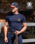 Pure Western Men's Samuel HP Trucker Cap. Man wearing a navy t-shirt with a logo and a cap, standing next to a horse with 'Pure Western' branding.