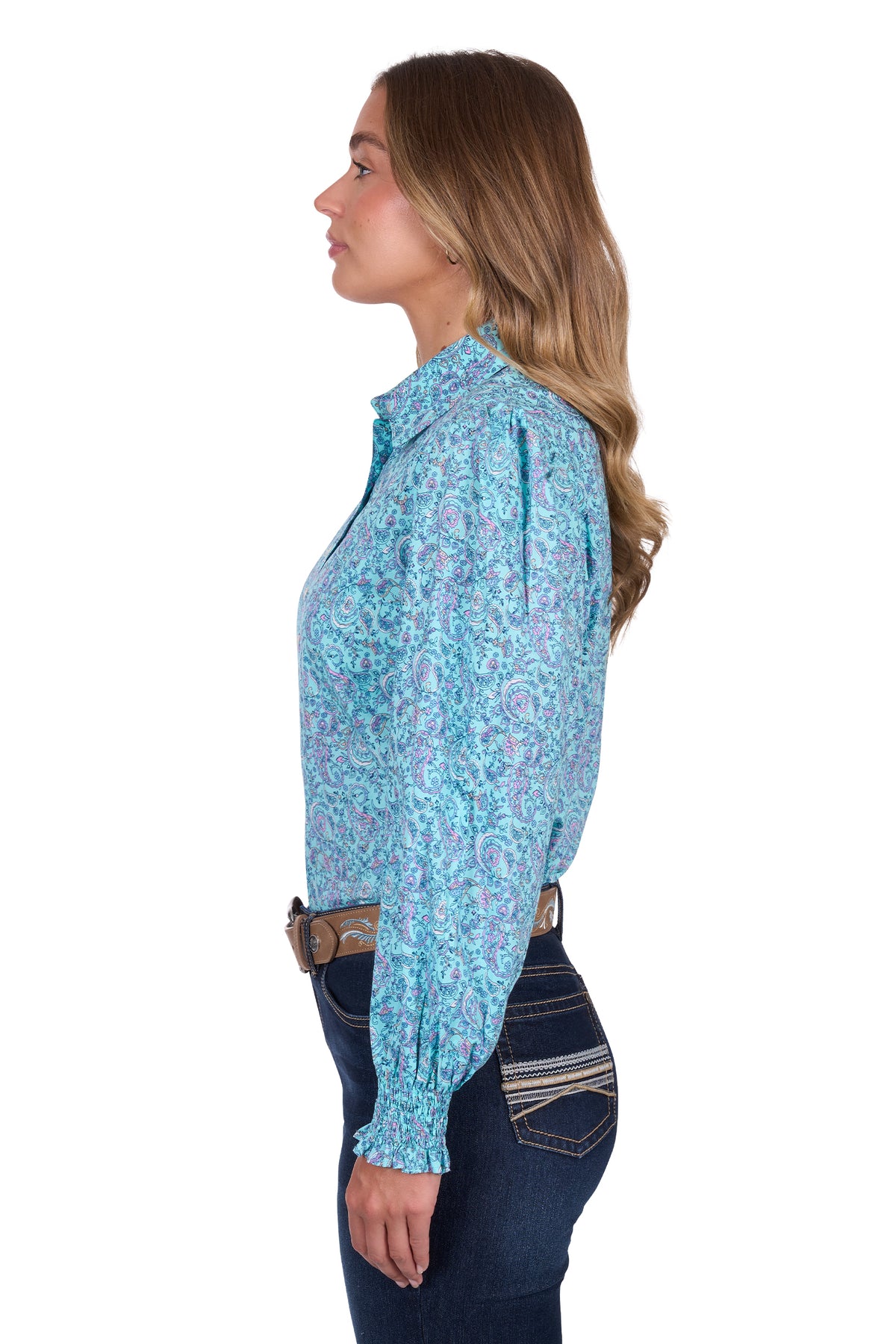 Pure Western Women's Riley L/S Western Shirt. Woman wearing a turquoise patterned long-sleeve shirt and jeans on a white background