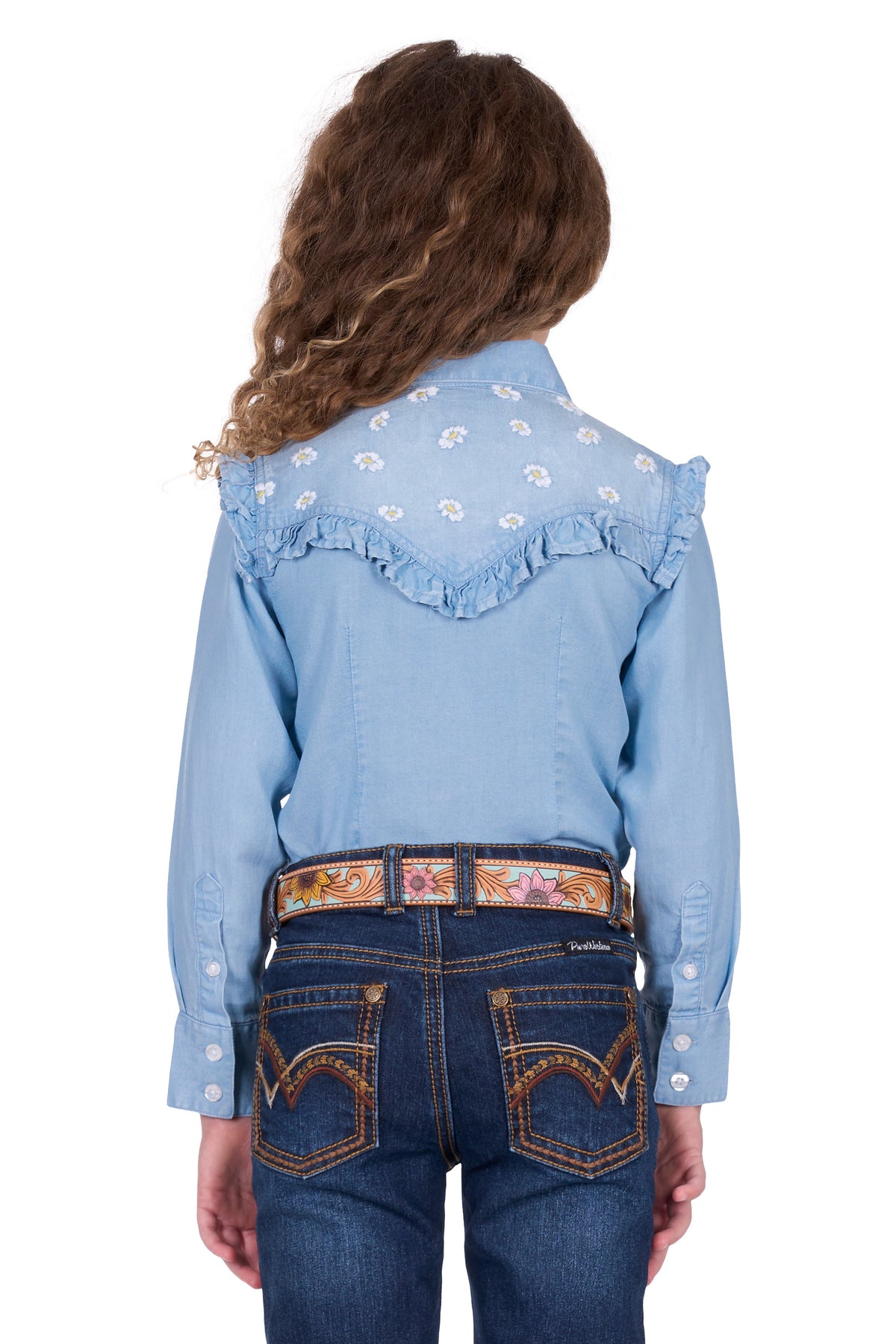 Pure Western Girl's Pheobe L/S Western Shirt. Person wearing a light blue denim shirt with floral patterns and dark blue jeans on a white background