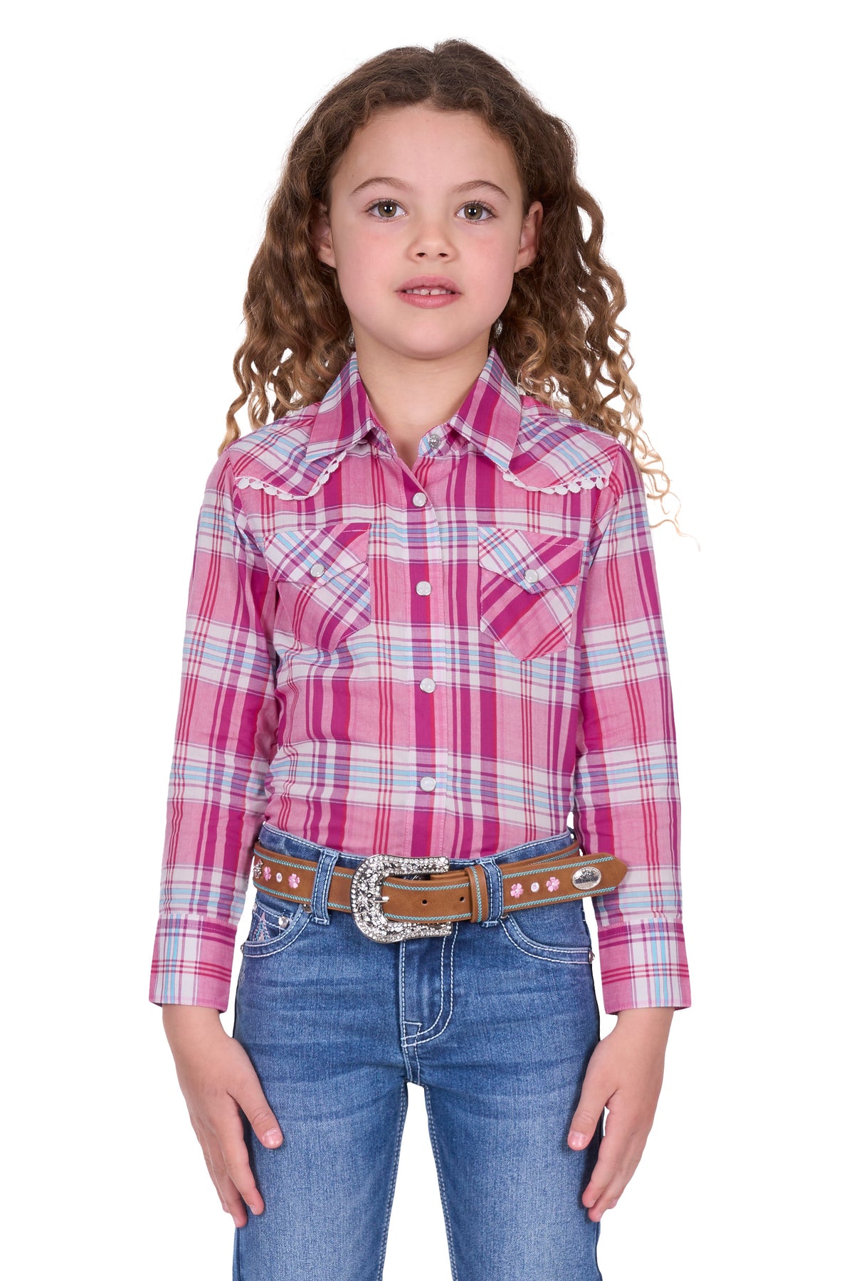 Pure Western Girl's Leni L/S Western Shirt. Young girl wearing a pink plaid shirt and blue jeans on a white background