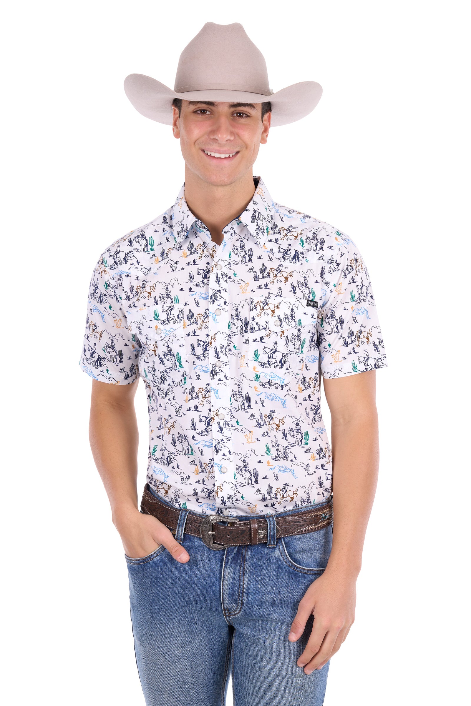 A man wearing a light beige cowboy hat, a short-sleeve button-up shirt with a dense multicolor western print, blue jeans, and a brown belt, standing against a plain white background.