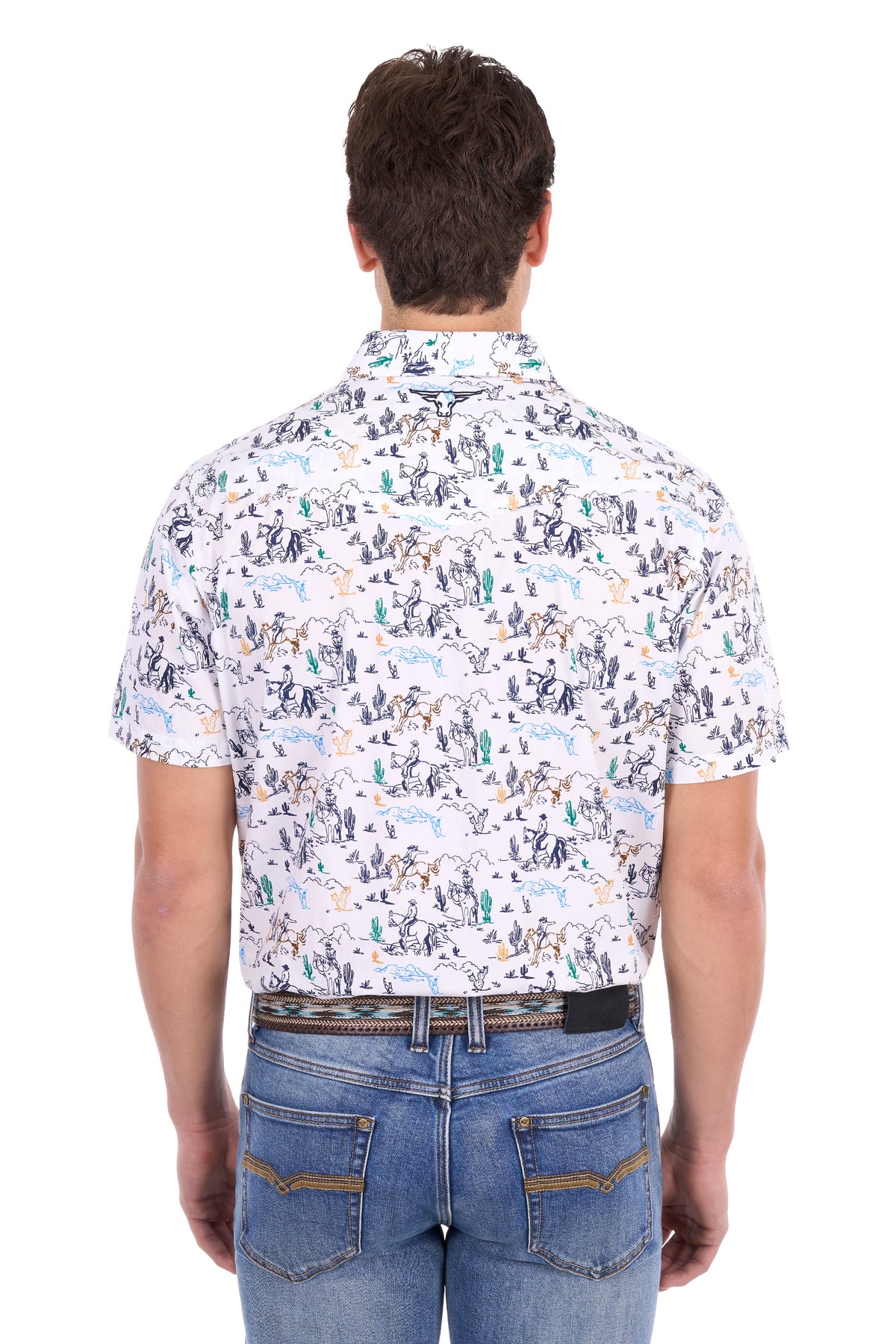 A man viewed from behind wearing a short-sleeve button-up shirt with a detailed desert animal and cactus pattern on a white base, paired with blue jeans.