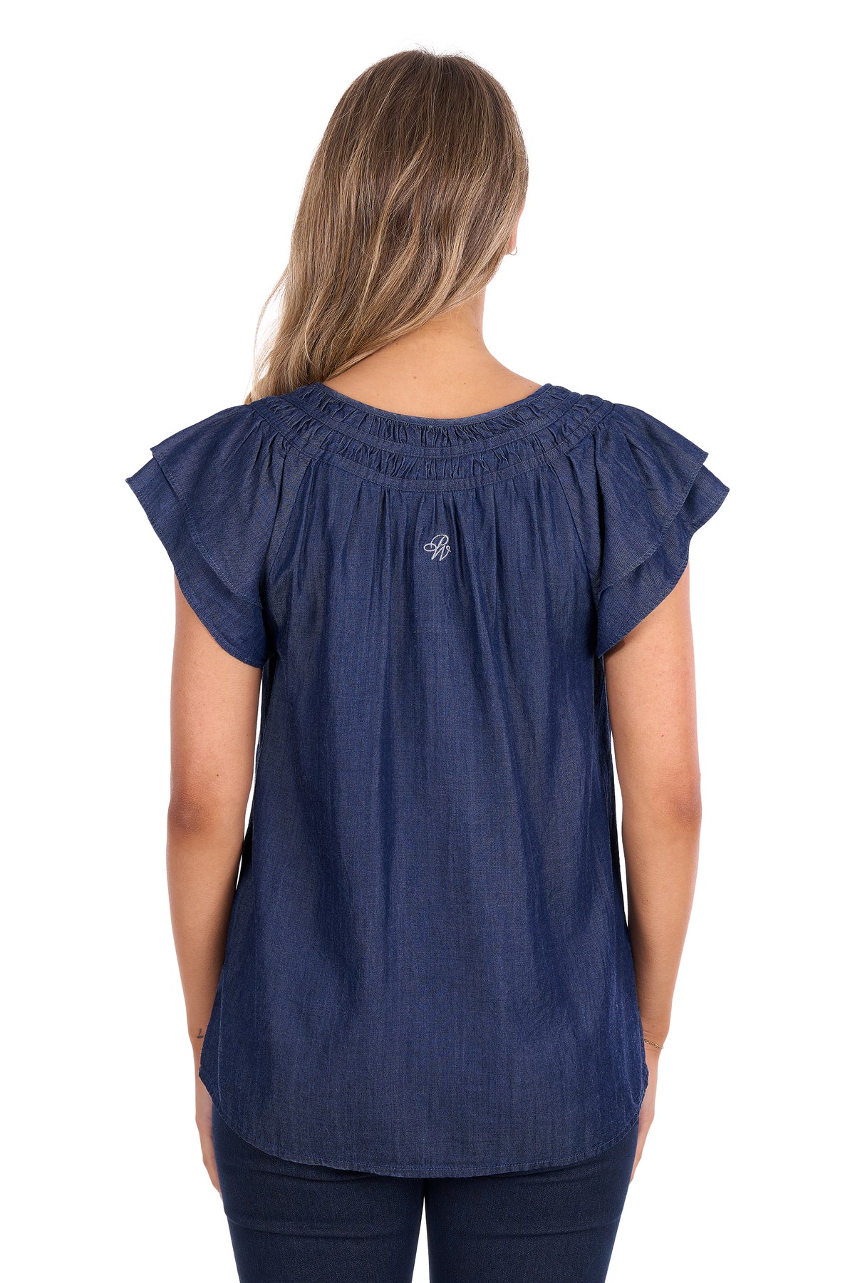 A woman viewed from the back wearing a navy blue short-sleeve top with ruffled shoulders and a small embroidered logo on the upper back, paired with dark pants against a plain white background.