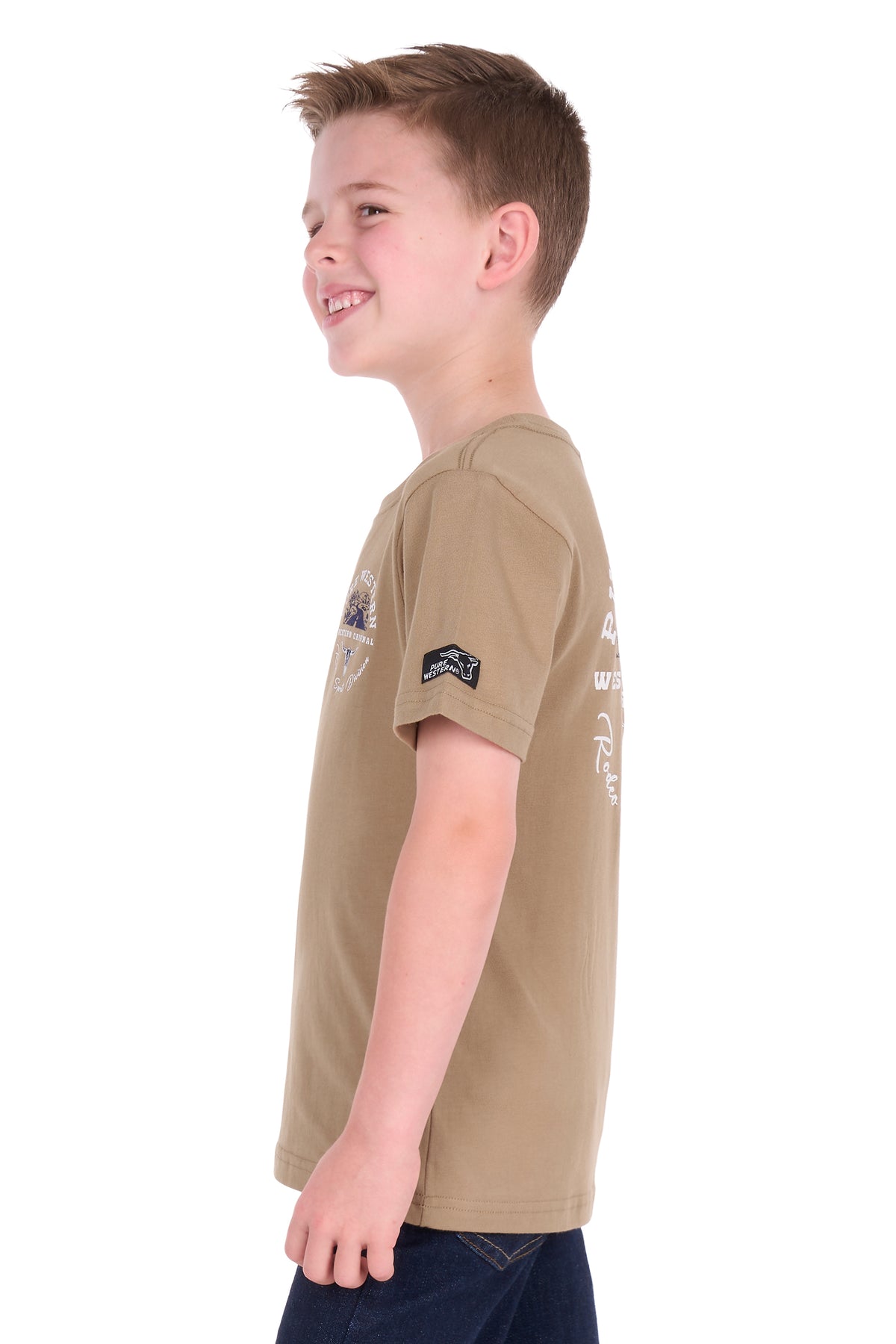 A young boy in profile wearing a tan short-sleeve t-shirt with a graphic on the left chest and a small patch on the right sleeve, set against a plain white background.