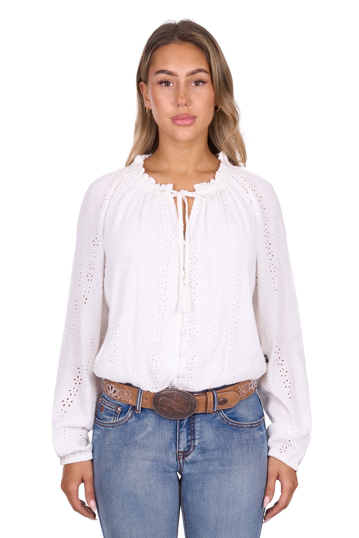 Woman wearing a white blouse with eyelet details and blue jeans on a white background
