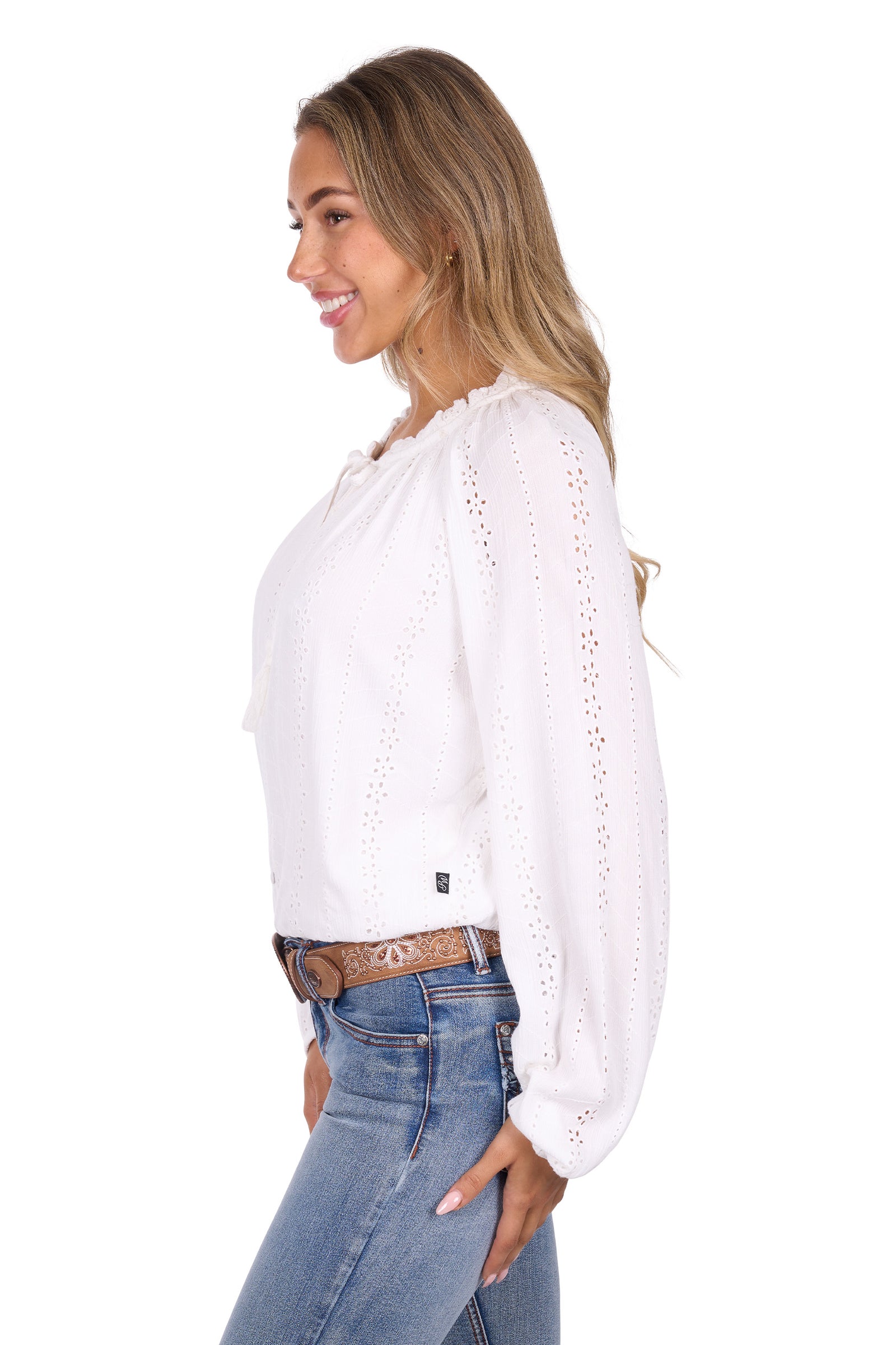 Woman wearing a white blouse with lace details and blue jeans on a white background