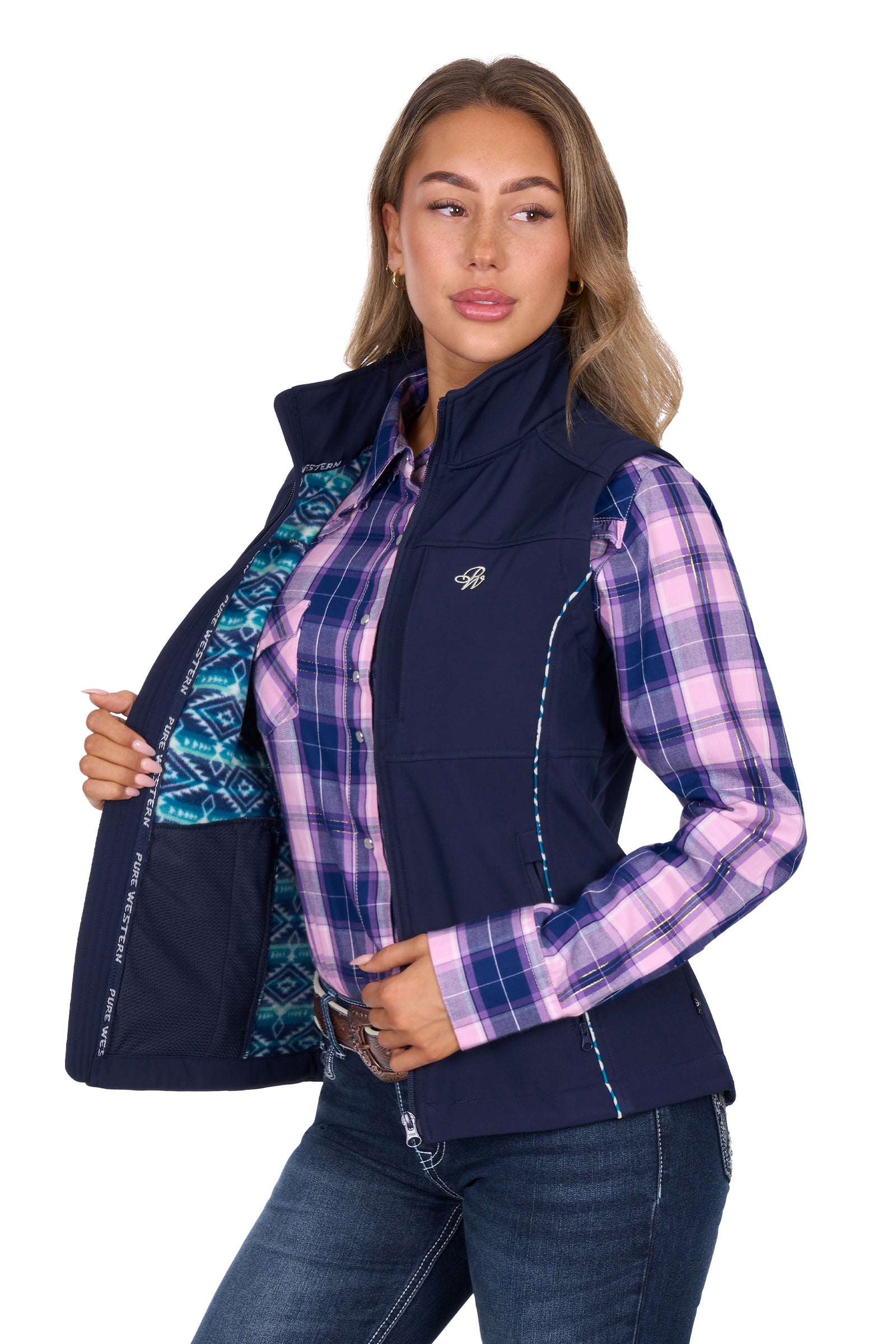 Woman wearing a navy vest over a plaid shirt with a visible logo on a white background