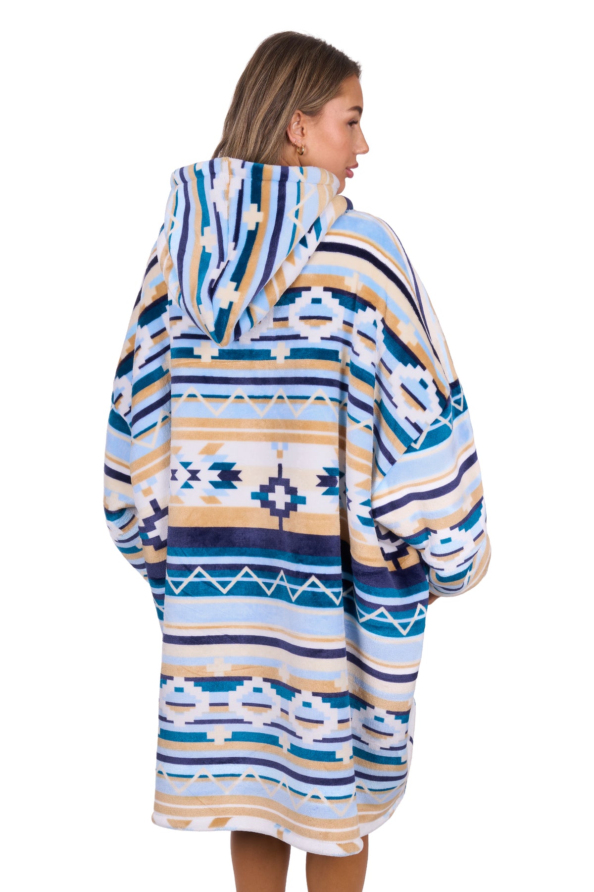 Person wearing a patterned poncho with a hood on a white background