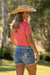 Pure Western Women's Imogen Western Shorts. Woman wearing a pink shirt, denim shorts, and a wide-brimmed hat outdoors.