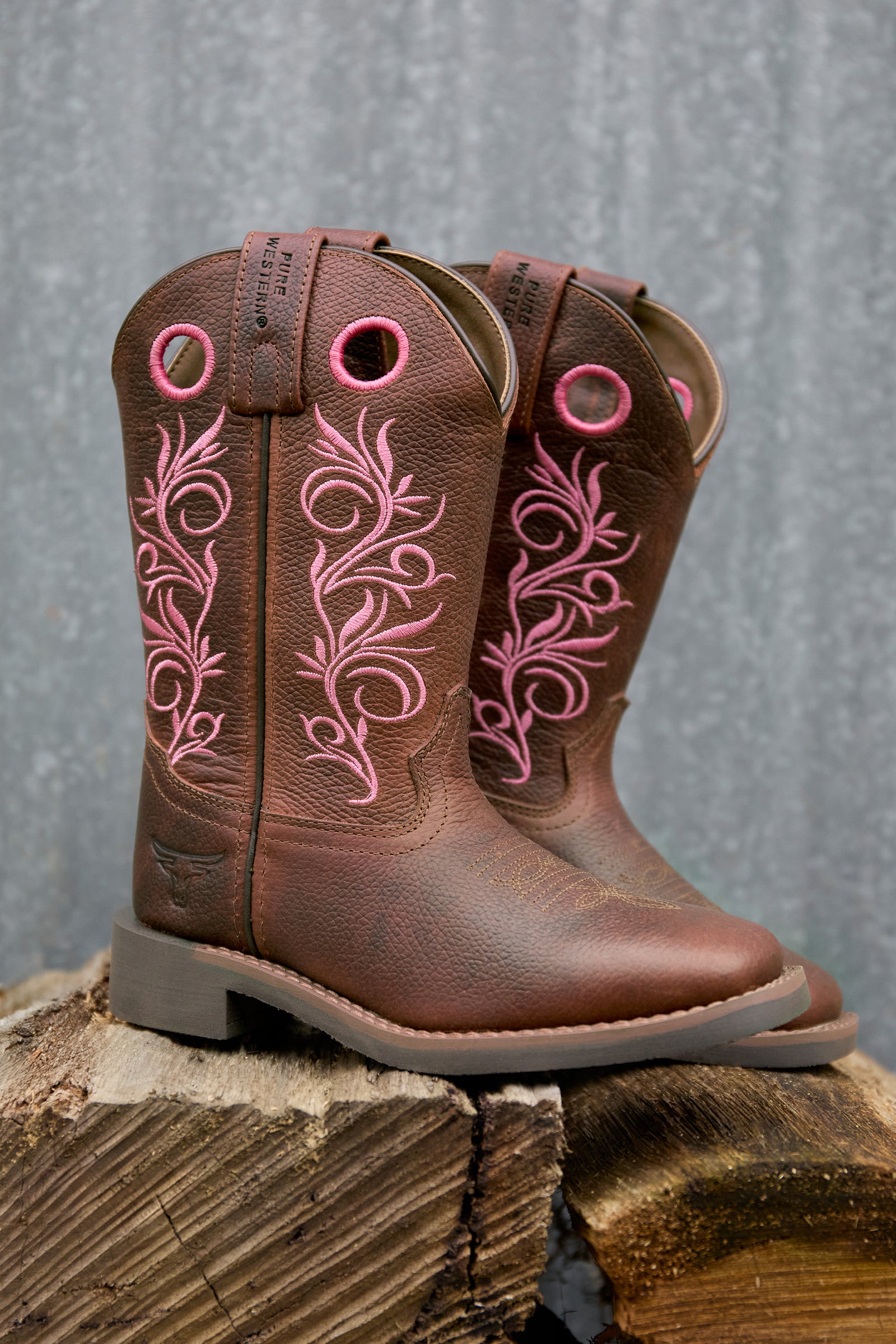 Brown cowboy boot with pink floral embroidery on a white background