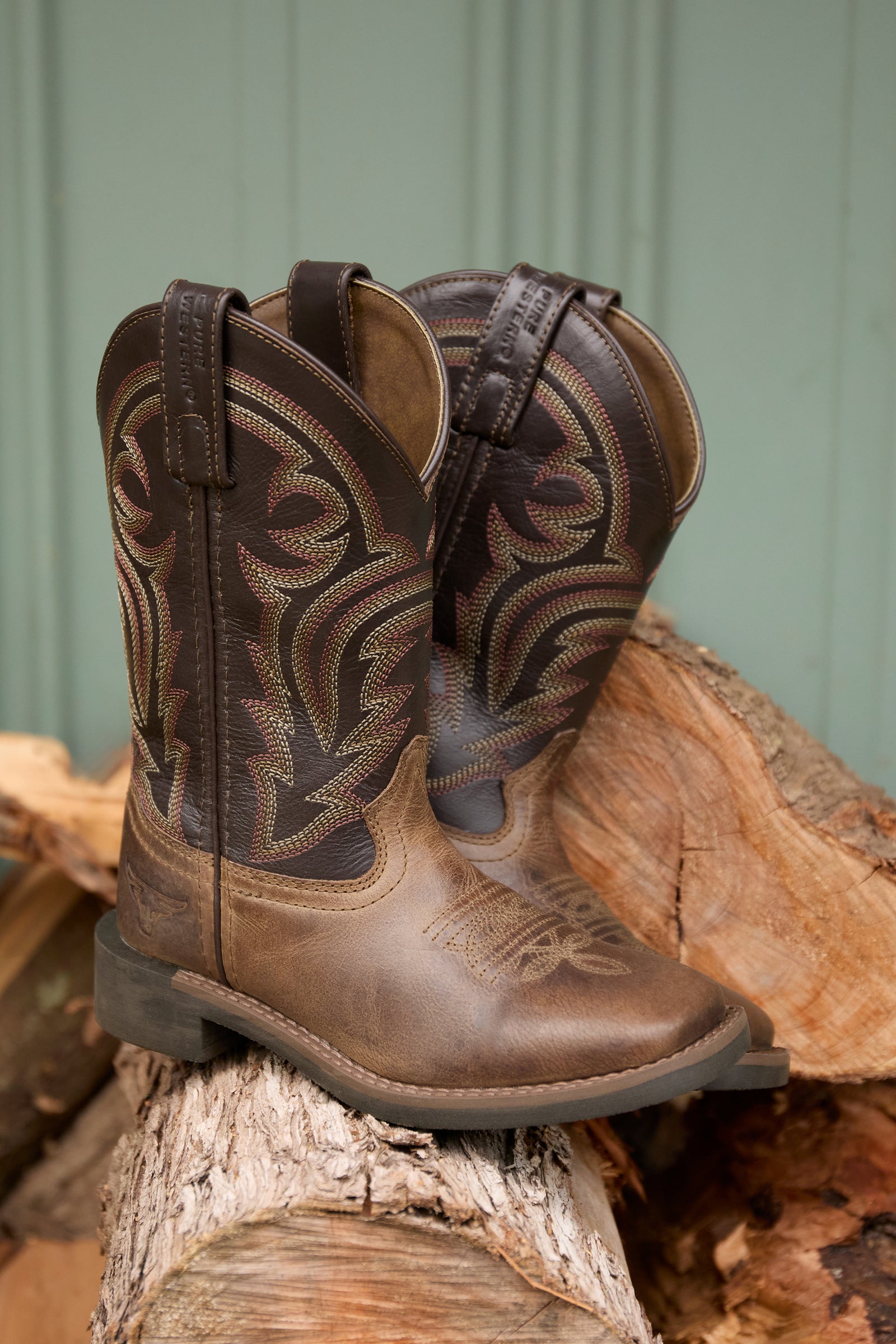 Brown cowboy boot with intricate design on a white background