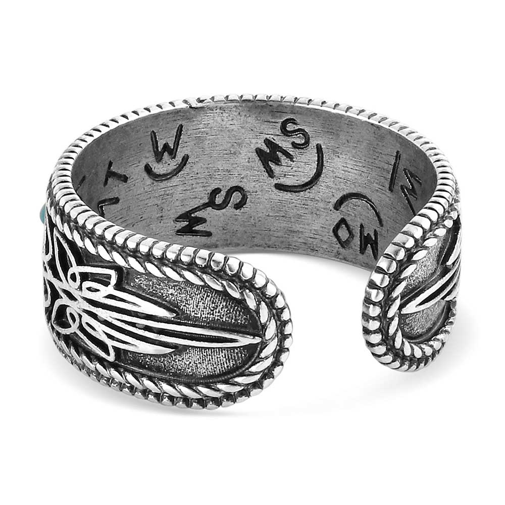 Silver ring with engraved designs on a white background