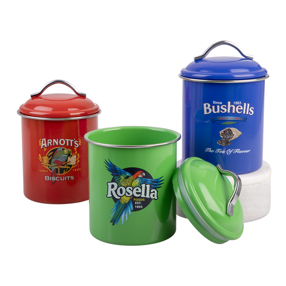 Three enamel metal canisters with lids in red, green, and blue, each featuring a large brand logo and illustration, displayed on a white background.
