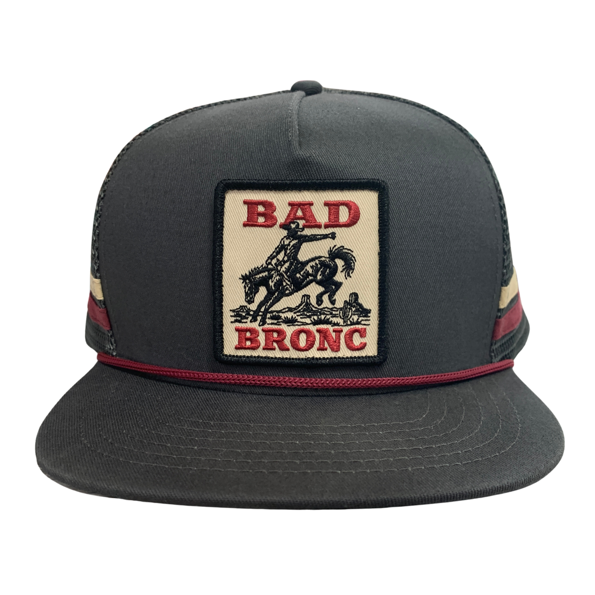 A dark gray trucker-style cap with a front patch reading 'BAD BRONC' and showing a cowboy riding a bucking bronco. The cap has dark mesh side panels and red accent stitching.