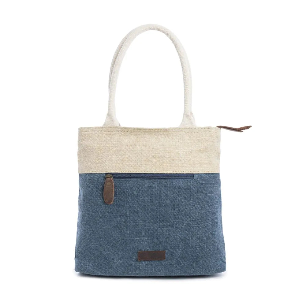 Women's Ports of Call Tote BagA denim blue and wheat colored tote bag with woven canvas handles, featuring decorative stitching and a tassel, with a text design on the front. 