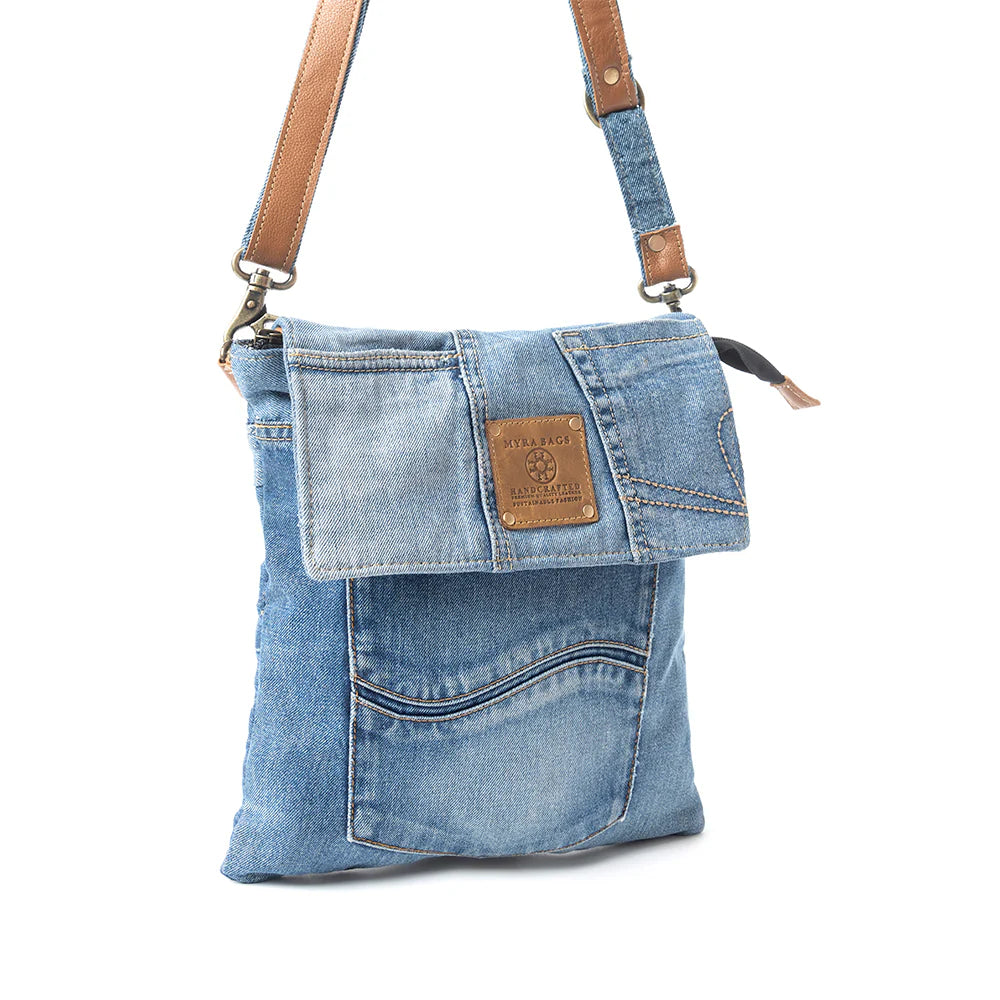 Denim handbag with brown leather straps on a white background