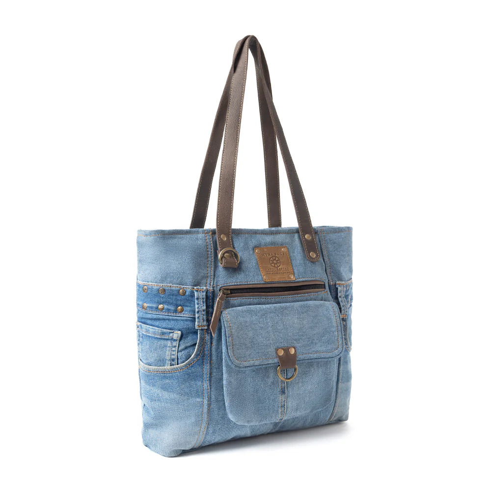Denim tote bag with brown leather accents on a white background