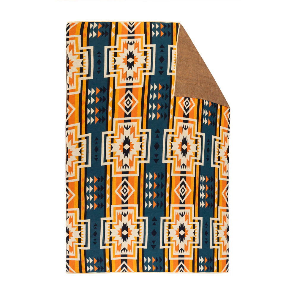 Sacred Star Valley Throw. Folded fabric with geometric pattern on a white background