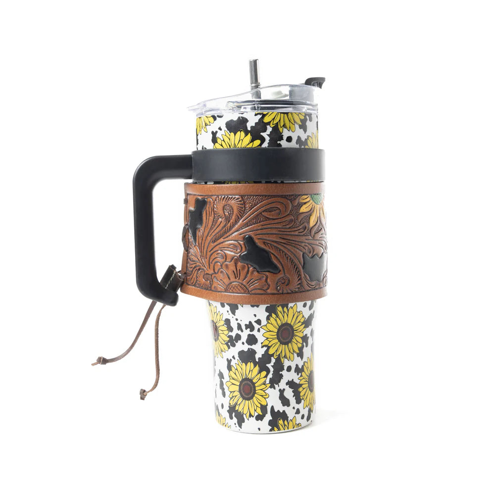 Wide Wyoming Tumbler In Yellow with Tooling. Tumbler with floral design and brown leather sleeve on a white background