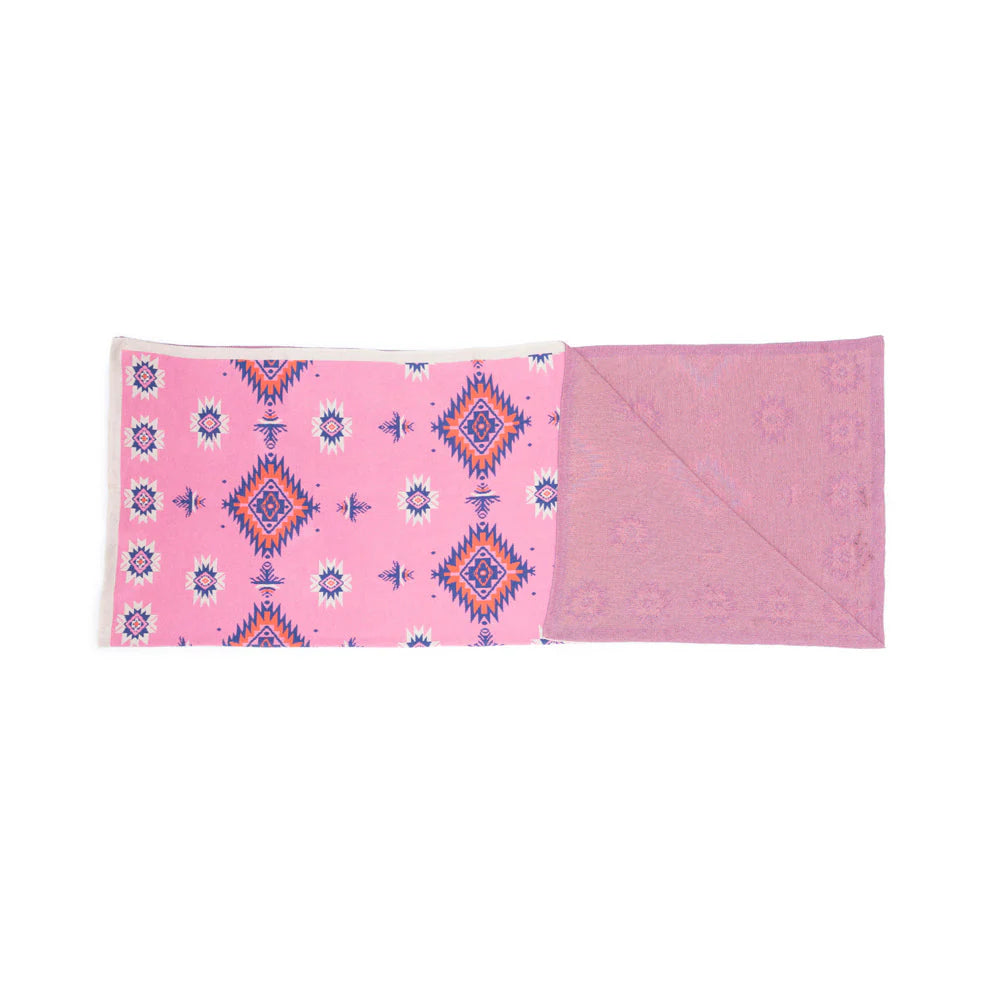 Pink quilt with geometric pattern on a white background