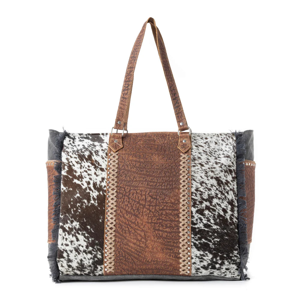 Saddle Belle Weekender Bag in Wild Clay. Tote bag with cowhide leather pattern on a white background