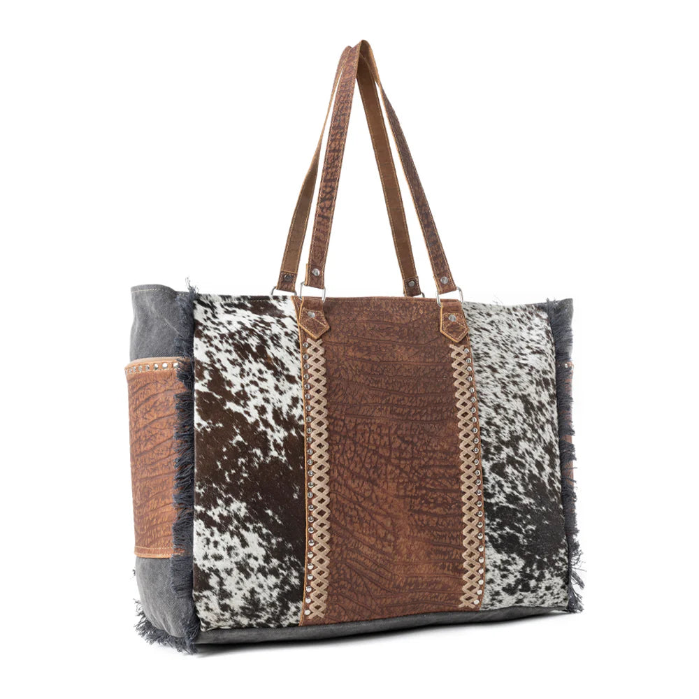 Saddle Belle Weekender Bag in Wild Clay. Tote bag with cowhide leather pattern on a white background