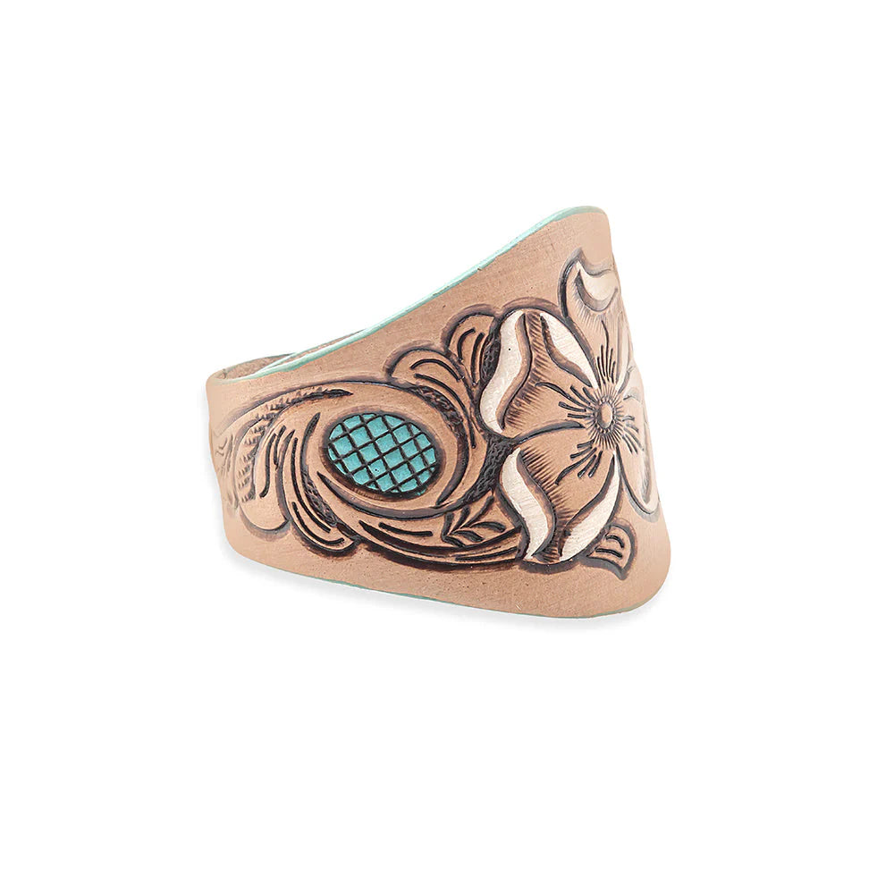 Copper ring with intricate designs and a turquoise stone on a white background