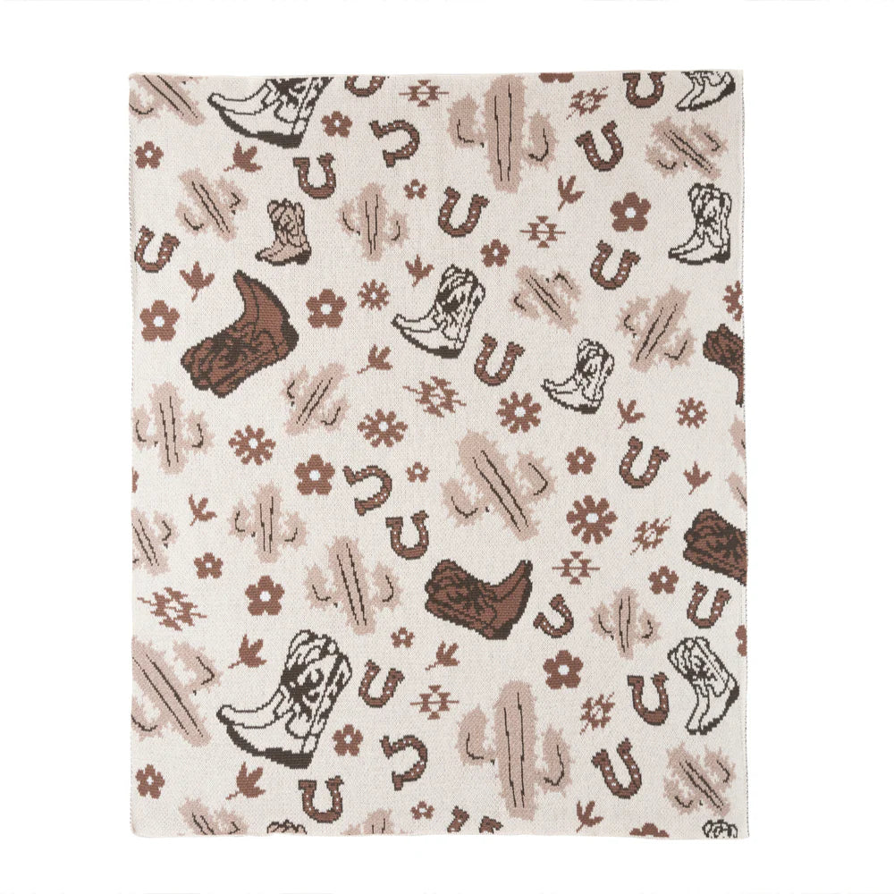 Wild West Wrap Baby Blanket. Patterned fabric with cowboy boots, cacti, and horseshoes on a beige background
