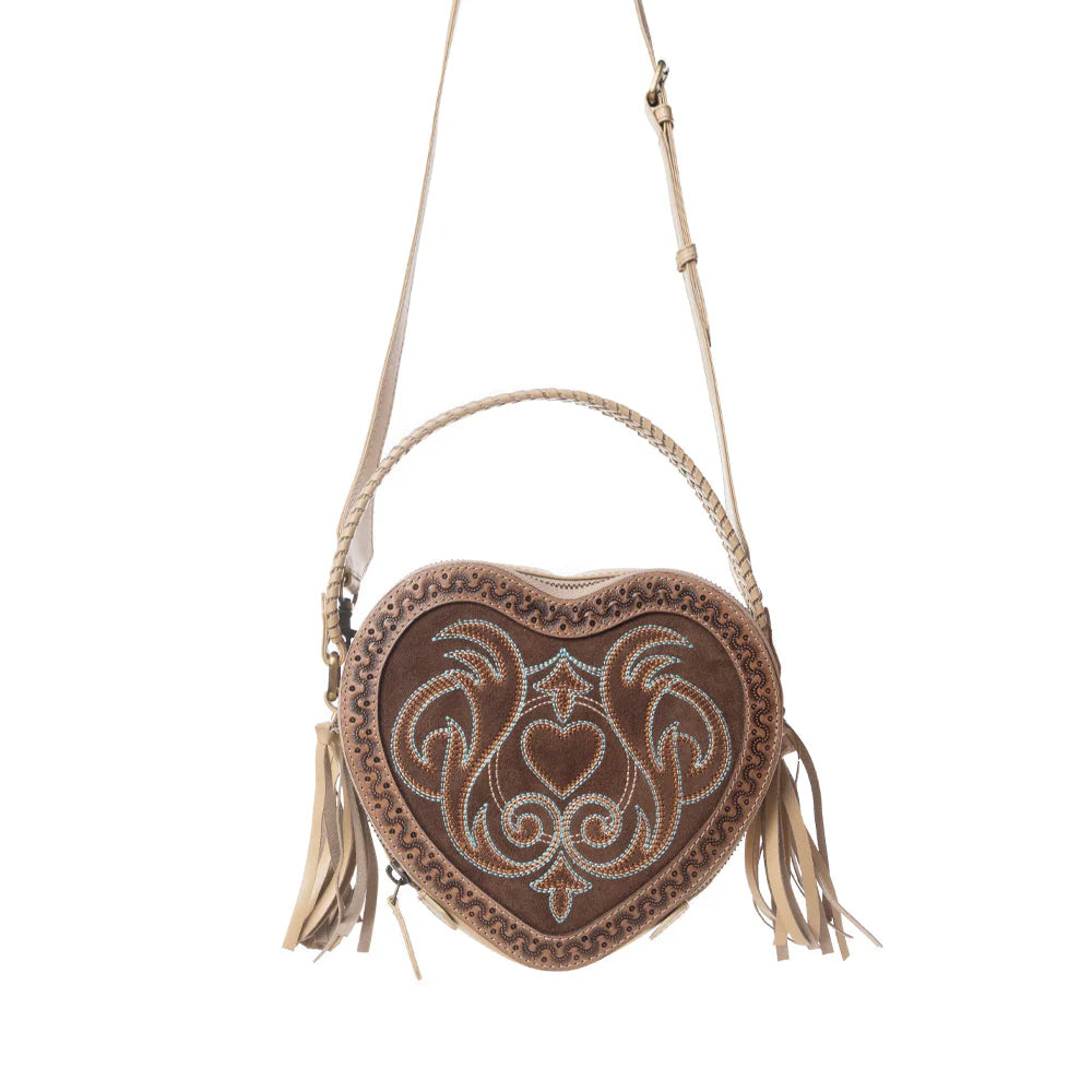 Heart-shaped handbag with intricate designs and tassels on a white background