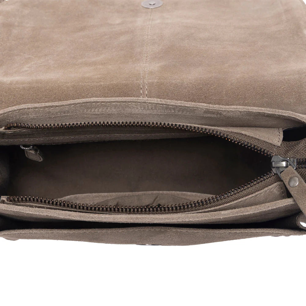 Close-up of a brown leather bag with zippers on a white background