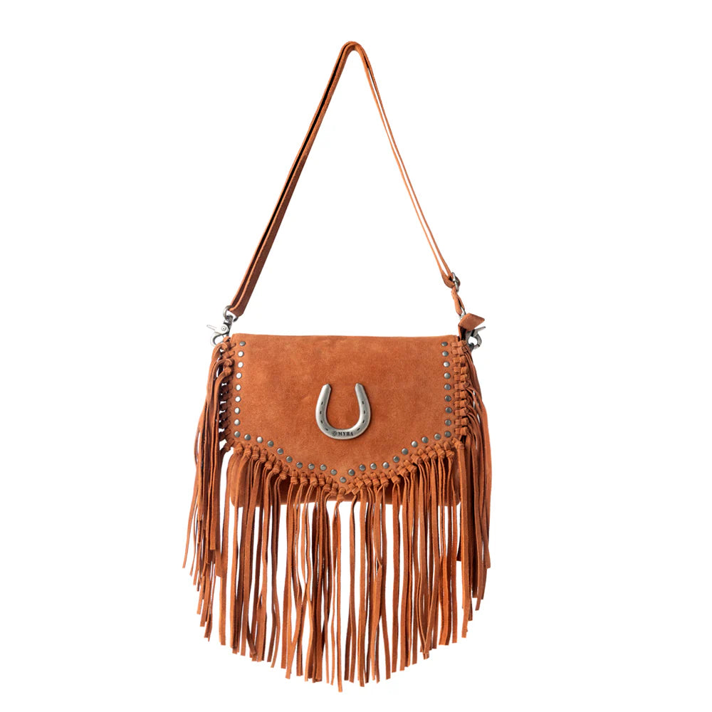 Brown suede handbag with fringe and a horseshoe charm on a white background